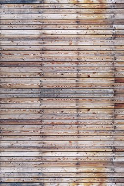Yatay olarak yerleştirilmiş çekiç çivili eski kahverengi ahşap tahtalardan oluşan katı bir duvar. Doku, arkaplan, iç mekan kavramı