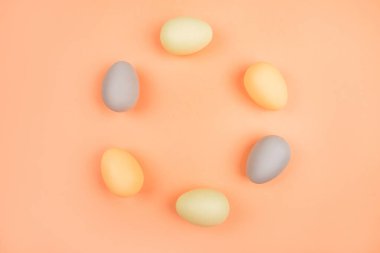 Şeftali arka plan üzerinde izole boyalı üzerinde yeşil, sarı ve gri Paskalya yumurta döngüsü. Paskalya Tema flatlay.