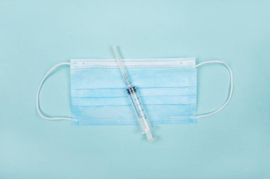 Soğuk algınlığı ve grip önleme için tıbbi koruyucu donanıma sahip düz alan mavi arka planda izole edildi.