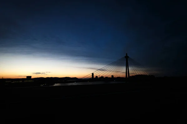 Köprü ve şehir mavi gökyüzü altın günbatımı üzerinde güzel gün batımı