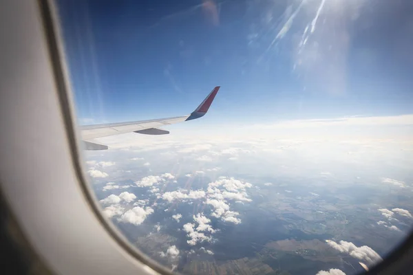 Uçak penceresinden harika bir manzara. arazi mavi gökyüzü ve Güneş'ten uçak ışığı