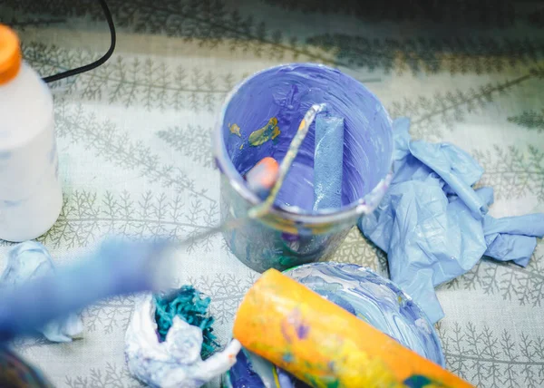 Okulda, anaokulunda ya da eğitim merkezinde çizim odası dersleri. Atmosfer çiziyorum. Mavi ve sarı renk. Boya silindiri kovada yatıyor.