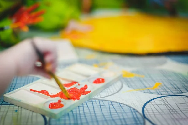 Çocuk resim çizmeye başlamadan önce fırçayla boyaya dalmış. Okulda, anaokulunda ya da eğitim merkezinde çizim odası dersleri