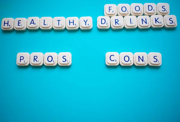 Gesunde Lebensmittel und Getränke: Liste der Vor- und Nachteile, mit Kopierraum, um Argumente hinzuzufügen, die mit Spielbuchstaben gemacht wurden — Stockfoto