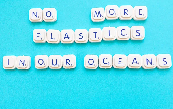 Tidak ada lagi plastik di lautan kita, pesan terhadap polusi plastik dengan latar belakang biru yang dibuat dengan huruf-huruf bermain — Stok Foto