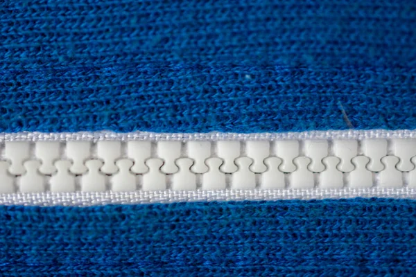 Zbliżenie Białego Plastikowego Zamka Zamkniętego Środku Niebieskiej Tkaniny Lewej Prawej — Zdjęcie stockowe