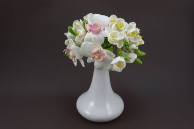 Hand made polymer clay bouquet in a white vase on a dark backgro clipart
