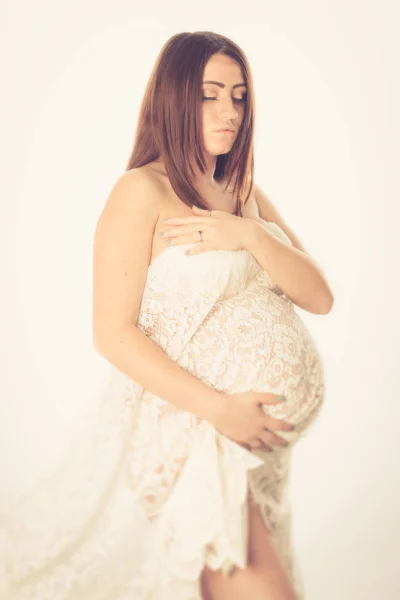 Gravid kvinna draperad i spets tyg — Stockfoto