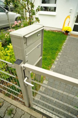 Yeni ev posta kutusu. Çite evin önünde metalik posta kutusu.