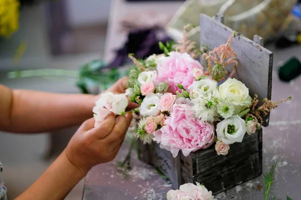 Florist made a floral arrangement. Florist woman prepare a floral arrangement for wedding event.