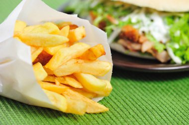Fast food. Arka plan bulanık karşı izole kağıt torba içinde patates.