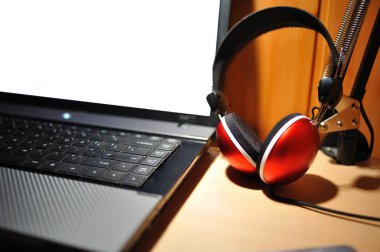 Stereo kulaklıklar. Resmi defter bilgisayar yanında kırmızı stereo kulaklık.