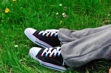 Siyah spor ayakkabı. Çimenlerin üzerinde rahatlatıcı zaman bahar sezonu.