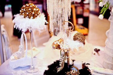 Düğün masa dekorasyonu. Düğün veya davette gibi belirli bir olay için masaya farklı altın ve beyaz aksesuarlar.