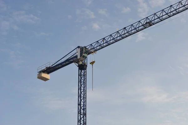 Isolated crane on site. Blue crane on construction site against blue sky in the background.