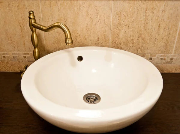 浴室内的陶瓷水槽 浴室内配有金色配件的圆形白色陶瓷水槽 — 图库照片