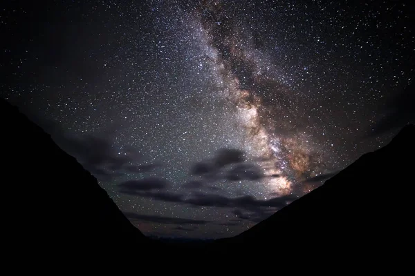 Milky Way φωτίζει τα σύννεφα στα βουνά. Οροπέδιο Καρά- — Φωτογραφία Αρχείου