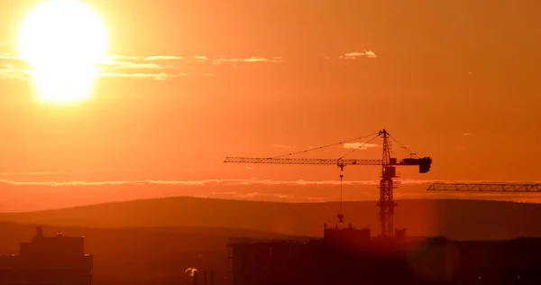 Tornkran mot bakgrund av den nedgående solen. Bakgrundsbelysning. Ekaterinburg, Ryssland — Stockfoto