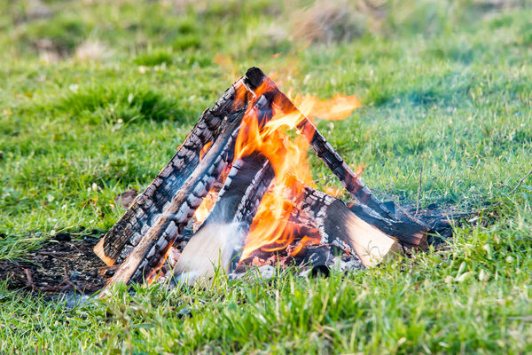 Bonfire on the field in the light of the setting su