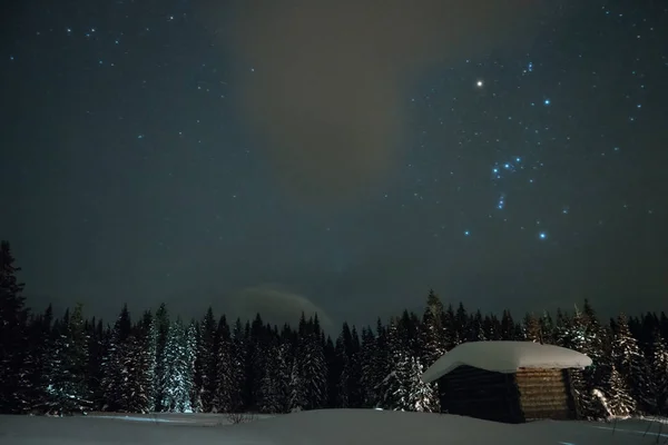 星降る冬の空の背景の小さな家 — ストック写真