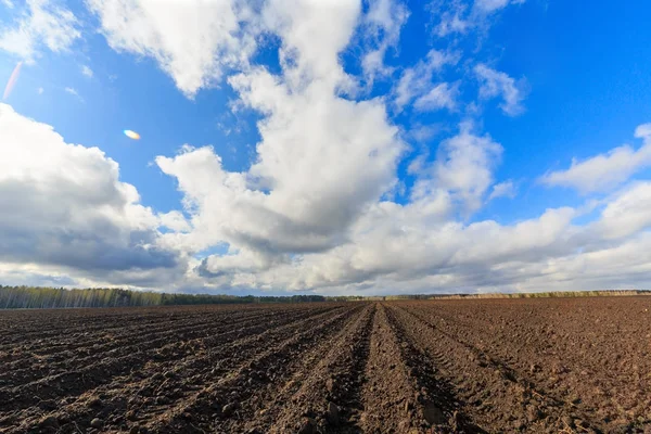 Wolken über Ackerland aus nächster Nähe. Zeitrunden lizenzfreie Stockbilder