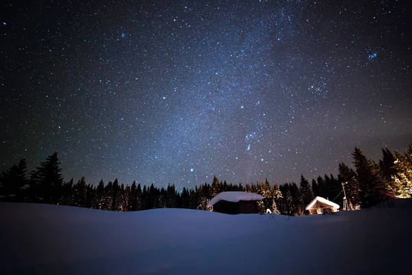 Het kleine huis op de achtergrond van de sterrenhemel winter hemel — Stockfoto