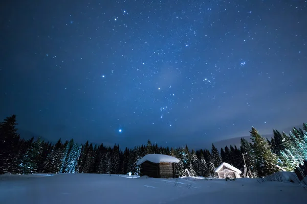 Het kleine huis op de achtergrond van de sterrenhemel winter hemel — Stockfoto