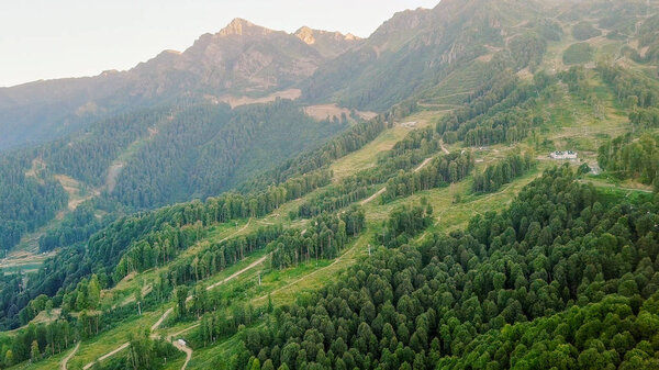 Rosa Khutor plateau, buildings, slopes and chair lifts. Aerial view at sunset 