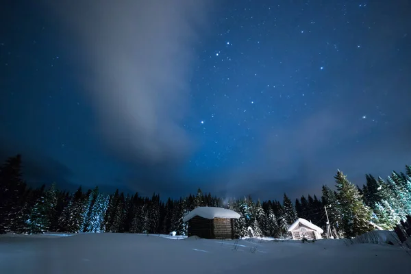 Маленький домик на фоне звездного зимнего неба — стоковое фото