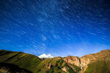 Yıldız solma çizgiler ve bulutlar üzerinde Elbruz Dağı çizme. Gece arazi