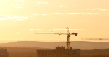 Kule Vinç karşı günbatımı gökyüzü inşaat sahasında. Ekaterinburg, Rusya Federasyonu. Video. UltraHD (4k)