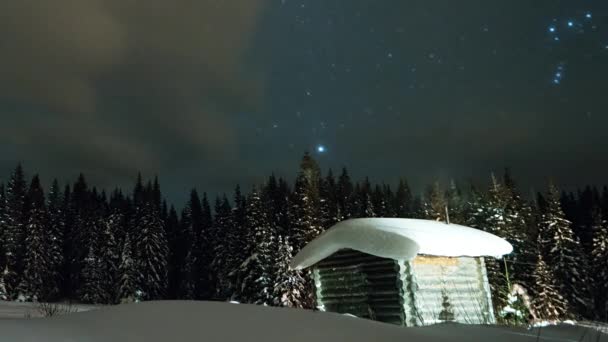 Lilla Huset Mot Stjärnhimlen Och Snöiga Barrskog Vinter Video Ultrahd — Stockvideo