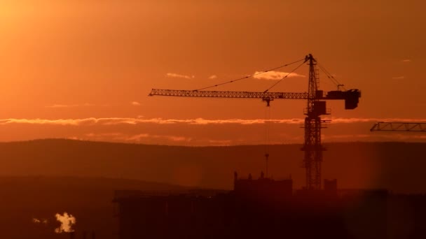 věžový jeřáb na staveništi proti západu slunce na obloze. Jekatěrinburg, Rusko. Video. UltraHD (4k)