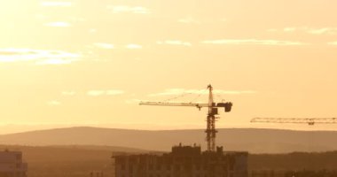 Kule Vinç karşı günbatımı gökyüzü inşaat sahasında. Ekaterinburg, Rusya Federasyonu. Video. UltraHD (4k)