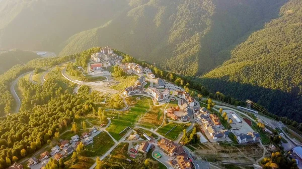 Rosa Khutor Yaylası, binalar, yamaçları ve sandalye asansörleri. Gün batımında havadan görünümü 