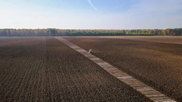 El tractor arada un campo con fertilizantes. Otoño, Rusia — Foto de Stock