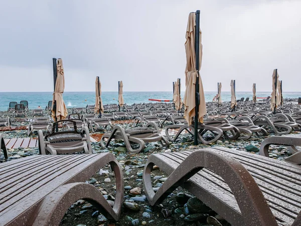 Playa de guijarros del Mar Negro con tumbonas y sombrillas en mal estado —  Fotos de Stock