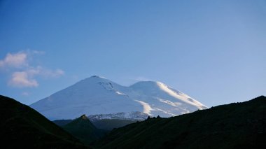 Gün batımında Elbrus karla kaplı dorukları. Kabardey çatışmalar işgalciler, Russi
