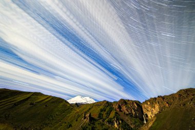 Yıldız solma çizgiler ve bulutlar üzerinde Elbruz Dağı çizme. Gece arazi