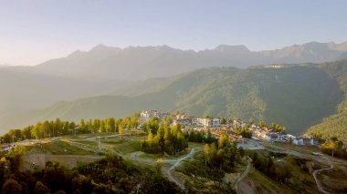 Rosa Khutor Yaylası, binalar, yamaçları ve sandalye asansörleri. Gün batımında havadan görünümü 