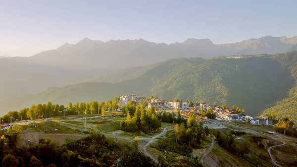 Rosa Khutor plateau, buildings, slopes and chair lifts. Aerial view at sunset 