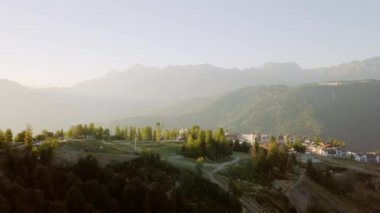 Rosa Khutor Yaylası, yamaçları, ağaçlar ve sandalye Asansörler. Gün batımında havadan görünümü. Video. UltraHD (4k)
