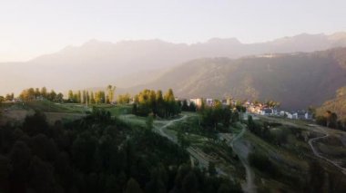 Rosa Khutor Yaylası, yamaçları, ağaçlar ve sandalye Asansörler. Gün batımında havadan görünümü. Video. UltraHD (4k)