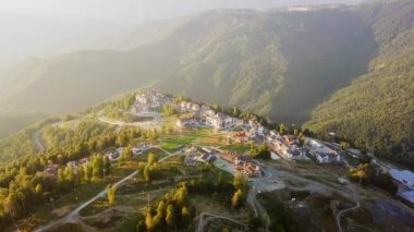 Rosa Khutor Yaylası, yamaçları, ağaçlar ve sandalye Asansörler. Gün batımında havadan görünümü. Video. UltraHD (4k)