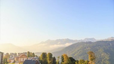 Bulutlar dağlar ve köy sıkın. Gece geliyor. Rosa Khutor Yaylası. Sochi, Rusya Federasyonu. Video. UltraHD (4k)