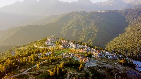 Rosa Khutor Yaylası, binalar, yamaçları ve sandalye asansörleri. Gün batımında havadan görünümü 
