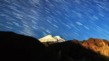 yıldız Elbruz Dağı üzerinde solmaya çizgiler çizin. Gece manzarası. Rusya. Video