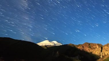 yıldız Elbruz Dağı üzerinde solmaya çizgiler çizin. Gece manzarası. Rusya. Video