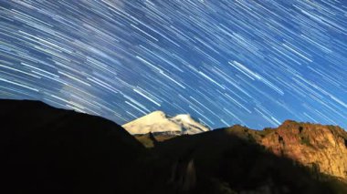yıldız Elbruz Dağı üzerinde solmaya çizgiler çizin. Gece manzarası. Rusya. Video