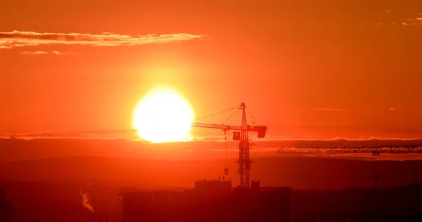 Tower crane against the backdrop of the setting sun. Backlight. Ekaterinburg, Russia — Stock Photo, Image